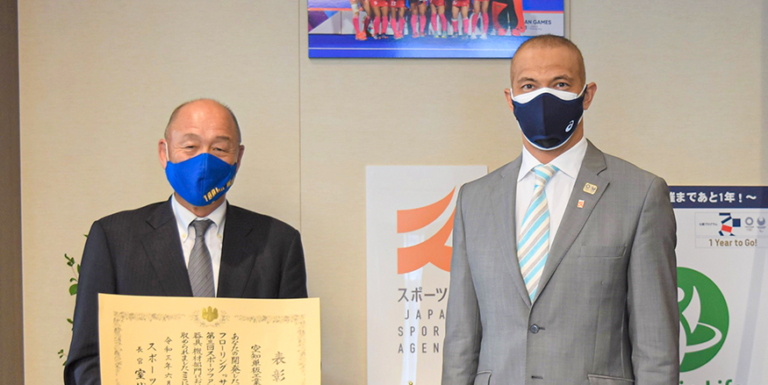 スポーツ庁で室伏長官（右）から表彰状を受けた松尾社長